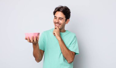 Mutlu, kendinden emin, elleri çenesinde gülümseyen genç bir İspanyol. boş kase kavramı