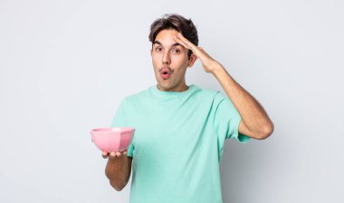 Genç İspanyol adam mutlu, şaşkın ve şaşırmış görünüyor. boş kase kavramı