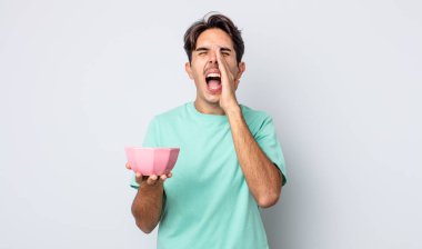 Genç İspanyol adam kendini mutlu hissediyor, elleri ağızının yanında bağırarak bağırıyor. boş kase kavramı