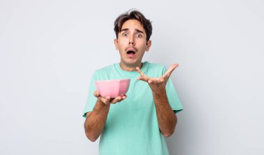 Genç İspanyol adam umutsuz, hayal kırıklığına uğramış ve stresli görünüyor. boş kase kavramı