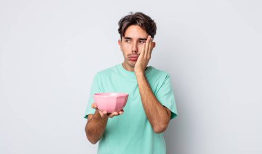 Genç İspanyol bir adam bıkkın, bezgin ve uykulu hissediyor. boş kase kavramı