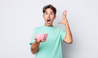 Genç İspanyol adam ellerini havaya kaldırarak çığlık atıyor. boş kase kavramı