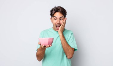 Genç İspanyol adam mutlu, heyecanlı ve şaşırmış hissediyor. boş kase kavramı