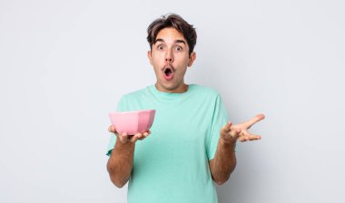 Genç İspanyol adam şok olmuş ve şaşırmış hissediyor. boş kase kavramı