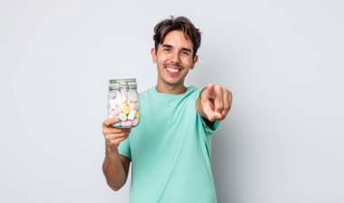 Genç İspanyol adam kamerayı göstererek seni seçiyor. jöle şekeri konsepti