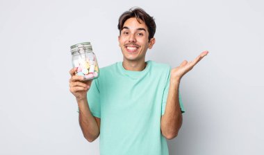 Genç İspanyol adam kendini mutlu hissediyor ve inanılmaz bir şeye hayret ediyor. jöle şekeri konsepti