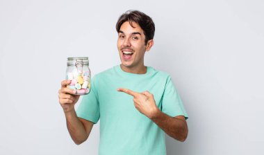 Genç İspanyol adam heyecanlı ve şaşırmış görünüyor. jöle şekeri konsepti