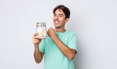 Genç İspanyol adam kendini mutlu hissediyor ve bir meydan okumayla yüzleşiyor ya da kutluyor. jöle şekeri konsepti