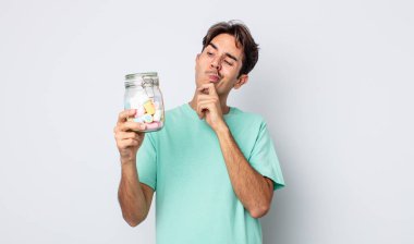 Genç İspanyol adam düşünüyor, kuşkulu ve şaşkın hissediyor. jöle şekeri konsepti