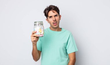Genç İspanyol adam şaşkın ve şaşkın hissediyor. jöle şekeri konsepti