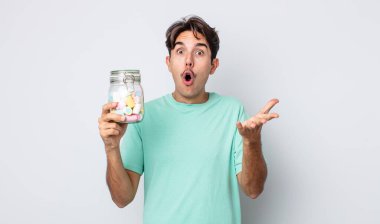 Genç İspanyol adam şok olmuş ve şaşırmış hissediyor. jöle şekeri konsepti