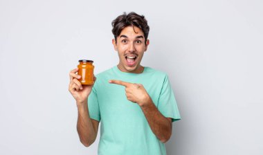 Genç İspanyol adam heyecanlı ve şaşırmış görünüyor. şeftali reçeli konsepti