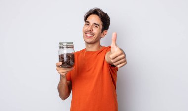 Genç İspanyol adam gururlu, olumlu bir şekilde gülümsüyor. kahve çekirdeği konsepti