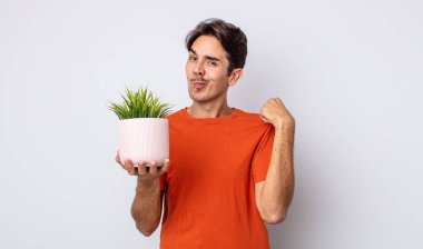 Genç İspanyol adam kibirli, başarılı, pozitif ve gururlu görünüyor. dekoratif bitki konsepti