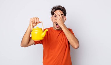 Genç İspanyol bir adam şok olmuş, korkmuş ya da korkmuş görünüyor. Yüzü elle kapatılmış. çaydanlık konsepti