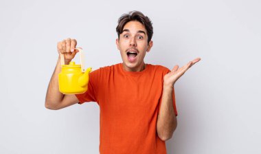 Genç İspanyol adam kendini mutlu hissediyor ve inanılmaz bir şeye hayret ediyor. çaydanlık konsepti