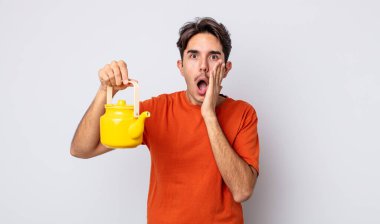 Genç İspanyol adam şok olmuş ve korkmuş hissediyor. çaydanlık konsepti