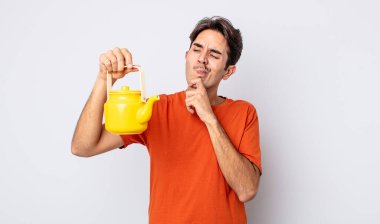 Genç İspanyol adam düşünüyor, kuşkulu ve şaşkın hissediyor. çaydanlık konsepti