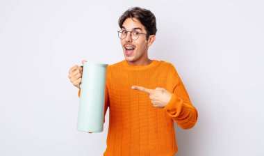 Genç İspanyol adam heyecanlı ve şaşırmış görünüyor. termos kavramı