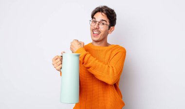 Genç İspanyol adam kendini mutlu hissediyor ve bir meydan okumayla yüzleşiyor ya da kutluyor. termos kavramı