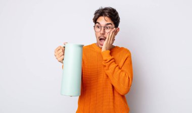 Genç İspanyol adam mutlu, heyecanlı ve şaşırmış hissediyor. termos kavramı