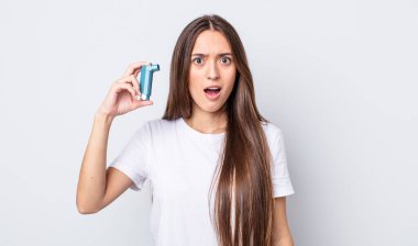 Genç ve güzel bir kadın çok şaşırmış ya da şaşkın görünüyor. astım konsepti