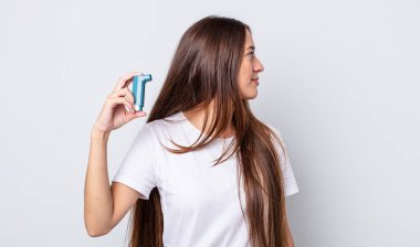 Profil görünümlü genç, güzel bir kadın hayal kuruyor ya da hayal kuruyor. astım konsepti