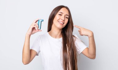 Genç ve güzel bir kadın, kendine güvenerek gülümsüyor. astım konsepti