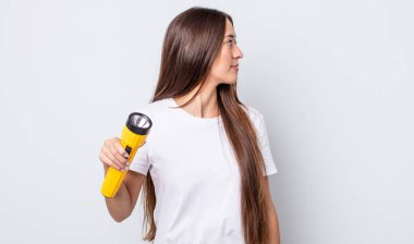 Profil görünümlü genç, güzel bir kadın hayal kuruyor ya da hayal kuruyor. fener konsepti