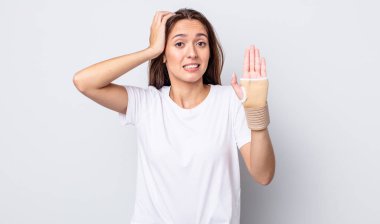 Genç ve güzel bir kadın gergin, endişeli ya da korkmuş hissediyor. Elleri başının üstünde. el bandajı konsepti