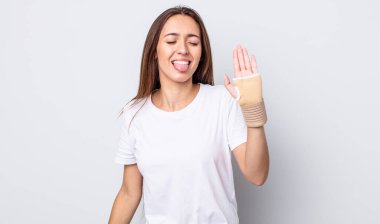 Neşeli ve asi tavırları olan genç ve güzel bir kadın, şaka yapıyor ve dilini dışarı çıkarıyor. el bandajı konsepti