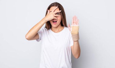 Genç, güzel bir kadın şok olmuş, korkmuş ya da korkmuş görünüyor. el bandajı konsepti