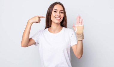 Genç ve güzel bir kadın, kendine güvenerek gülümsüyor. el bandajı konsepti