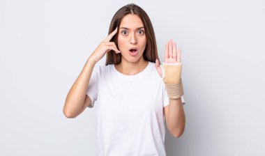 Genç, güzel bir kadın şaşırmış görünüyor, yeni bir düşünce, fikir ya da konsept fark ediyor. el bandajı konsepti