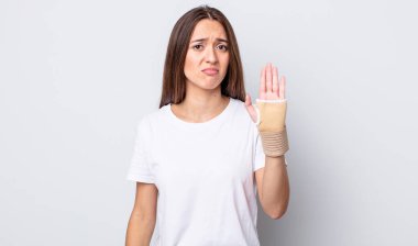 Genç, güzel bir kadın üzgün ve mızmızlanıyor. Mutsuz bir bakışı var ve ağlıyor. el bandajı konsepti