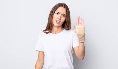 Genç ve güzel bir kadın şaşkın ve şaşkın hissediyor. el bandajı konsepti