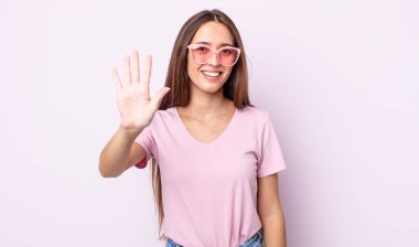 Genç, güzel bir bayan gülümsüyor ve arkadaş canlısı görünüyor, beş numarayı gösteriyor. pembe güneş gözlüğü konsepti