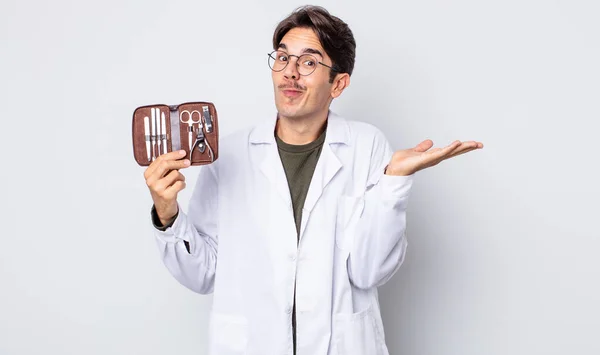 Young Hispanic Man Feeling Puzzled Confused Doubting Chiropodist Nails Tools — Stock Photo, Image