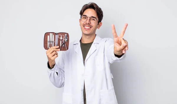 若いヒスパニック系の男は笑顔と幸せそうな 勝利や平和をジェスチャー カイロポディスト爪道具 — ストック写真