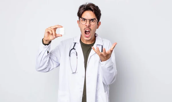 Młody Hiszpan Wygląda Wściekłego Wkurzonego Sfrustrowanego Lekarz Koncepcją Butelki Tabletek — Zdjęcie stockowe