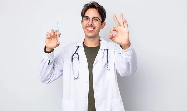 年轻的惊慌失措的男人感到快乐 以一个好的姿态表示赞同 医生注射器概念 — 图库照片