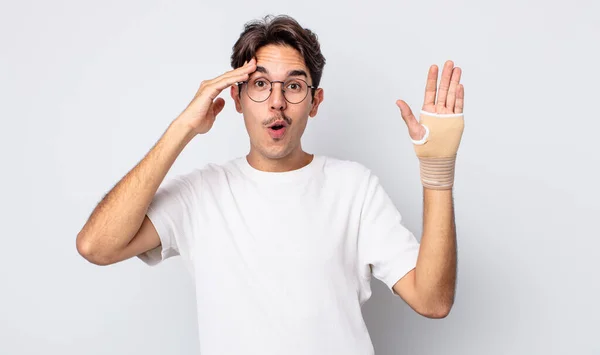 Young Hispanic Man Looking Happy Astonished Surprised Hand Bandage Concept — Stock Photo, Image