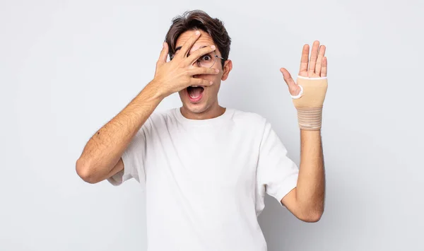 若いヒスパニック系の男は手で顔をカバーし ショック 恐怖や恐怖を探しています 手の包帯の概念 — ストック写真