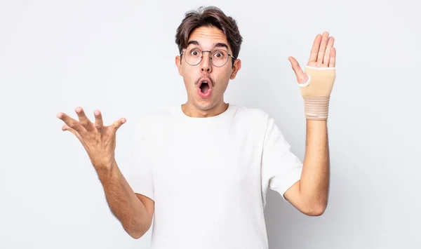 Young Hispanic Man Amazed Shocked Astonished Unbelievable Surprise Hand Bandage — Stock Photo, Image