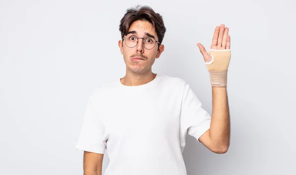 Young Hispanic Man Looking Puzzled Confused Hand Bandage Concept — Stock Photo, Image