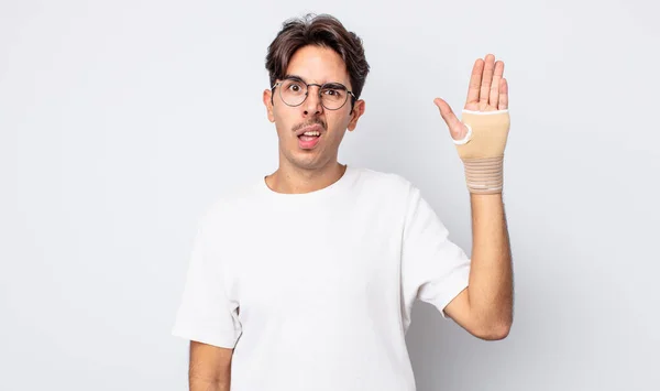 Young Hispanic Man Feeling Puzzled Confused Hand Bandage Concept — Stock Photo, Image