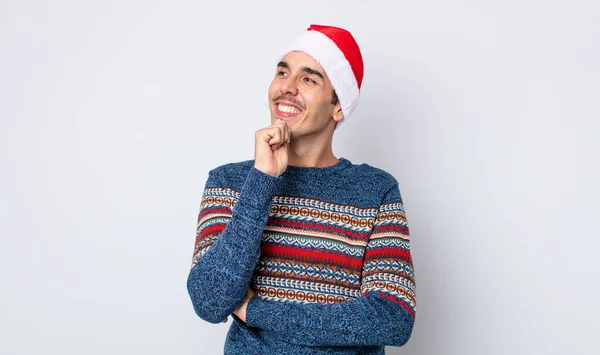 若いヒスパニック系の男は あごに手で幸せと自信を持って表情で笑っている 新年とクリスマスのコンセプト — ストック写真