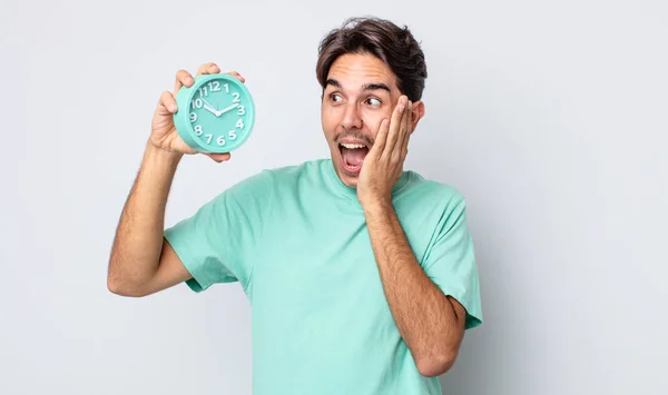 若いヒスパニック系の男は幸せ 興奮し 驚いて感じている 目覚まし時計のコンセプト — ストック写真