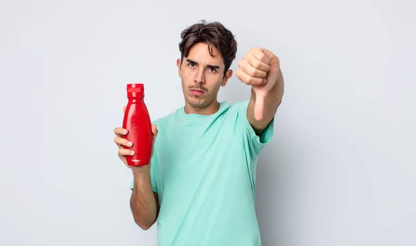 Młody Hiszpan Czuje Się Zły Pokazuje Opuszczone Kciuki Koncepcja Ketchupu — Zdjęcie stockowe