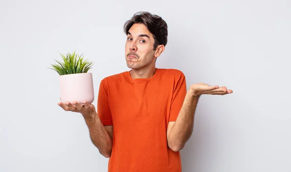 Jeune Homme Hispanique Sentant Perplexe Confus Doutant Concept Plante Décorative — Photo